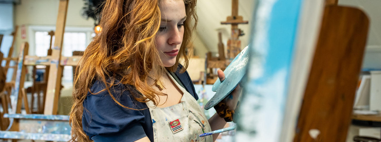 A woman painting a picture on an art easel